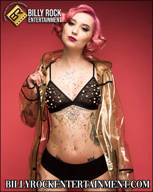 Elara posing in a glittering outfit with pink hair and confident smile.
