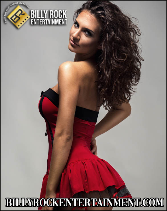 Raven Mystique in a red and black corset turning back