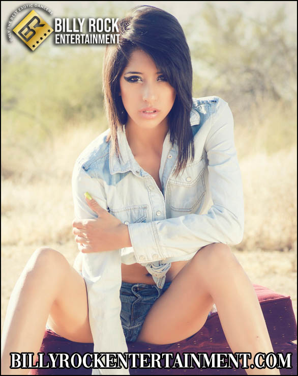 Selena Cruz posing in a casual denim outfit with black hair and brown eyes against a desert backdrop.