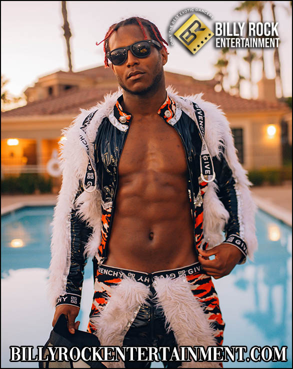 Shirtless, toned abs, red sunglasses, white jacket, striped pants by pool.