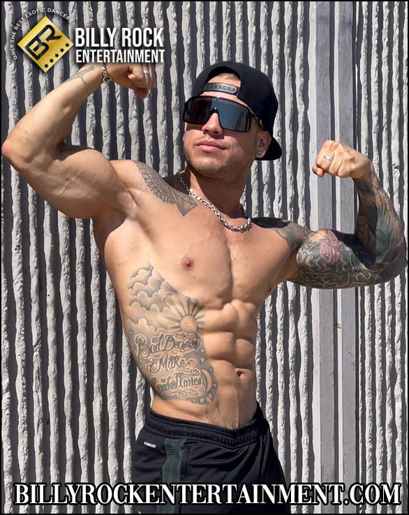 Oscar: Shirtless male dancer with abs, tattoos, cap, sunglasses, metal wall background.