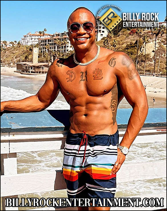 Sensation: Shirtless, beachfront balcony, tattoos, swim shorts, smiling.